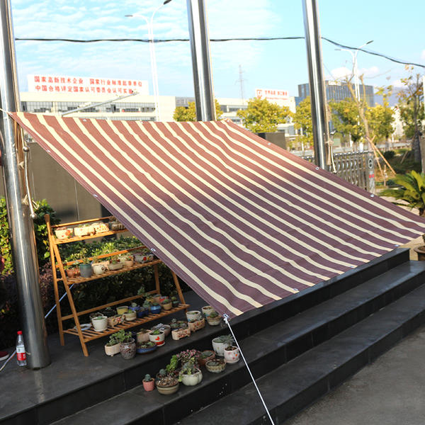 Pantalla de balcón con parasol de rayas marrones y blancas